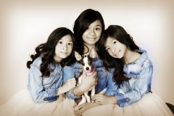 sisters wearing matching outfits holding Chihuahua dog
